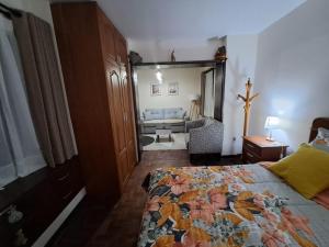 a bedroom with a bed and a living room at Bonito departamento Sopocachi centro in La Paz
