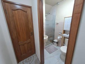 a bathroom with a toilet and a wooden door at Bonito departamento Sopocachi centro in La Paz