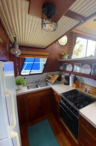a small kitchen with a stove and a refrigerator at The Lily Pad Boatel Houseboat in Savanna