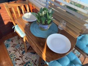 a wooden table with plates and a vase of flowers on it at The Lily Pad Boatel Houseboat in Savanna