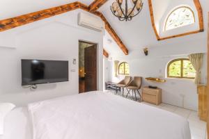 sypialnia z łóżkiem i telewizorem na ścianie w obiekcie Mushroom Forest Guesthouse Camping Site w mieście Puli