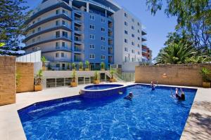 a swimming pool in front of a building at Sandy Cove Apartment The Entrance 24 in The Entrance
