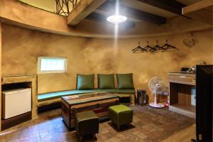 salon z zieloną kanapą i wentylatorem w obiekcie Mushroom Forest Guesthouse Camping Site w mieście Puli
