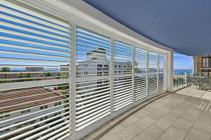 einen Balkon mit Jalousien am Fenster in der Unterkunft Sandy Cove Apartment The Entrance 22 in The Entrance