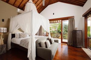 a bedroom with a bed with a canopy at Villa Uma Nina by Nakula in Jimbaran