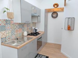 uma pequena cozinha com um lavatório e um fogão em Charming granite stone cottage between land and sea, in St Pol de Leon em Saint-Pol-de-Léon