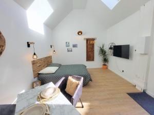 ein Schlafzimmer mit einem Bett und einem Tisch in einem Zimmer in der Unterkunft Charming granite stone cottage between land and sea, in St Pol de Leon in Saint-Pol-de-Léon