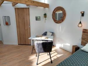 um quarto com uma mesa, uma cama e um espelho em Charming granite stone cottage between land and sea, in St Pol de Leon em Saint-Pol-de-Léon