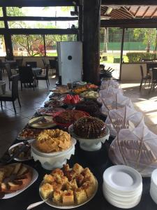 una mesa con un montón de diferentes tipos de repostería en Flat no Nannai Residence, en Porto de Galinhas