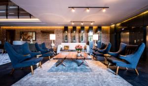 a living room with blue chairs and a table at Square Small Luxury Hotel - Nuevo Consulado in Guadalajara