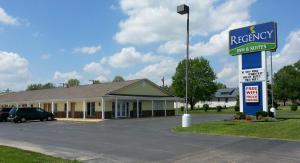 Una posada regency y suites firman frente a un estacionamiento en Regency Inn Pittsburg, en Pittsburg