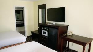 a hotel room with a television and a telephone at Regency Inn Pittsburg in Pittsburg