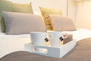 two coffee cups on a tray on a bed at Luxurious Loft apt w-View walk city center New Delft Family XL in Delft