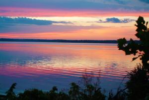 a sunset over a large body of water at Floating Cottage on the River Nantucket in Savanna +6 photos