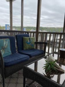 un balcón con 2 sillas y una mesa con una planta en Floating Cottage on the River Nantucket, en Savanna