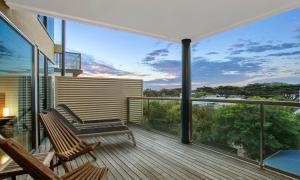 a balcony with two chairs and a view of the ocean at Belbourie in Queenscliff