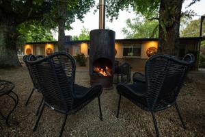 2 sillas y chimenea frente a una casa en Adina Lodge Holiday Apartments, en Bright