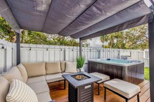 a patio with a couch and a hot tub at * NEW* The Bungalow Jupiter! - Moremoments Rentals in Jupiter