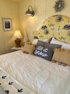 een slaapkamer met een wit bed met een bloemrijk hoofdeinde bij Cozy Wintertime Nantucket Cottage Getaway in Savanna +17 foto's
