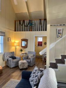 een woonkamer met een bank en een trap bij Cozy Wintertime Nantucket Cottage Getaway in Savanna