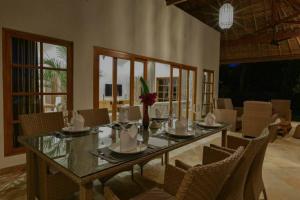 comedor con mesa de cristal y sillas en Beachfront Private VILLA & POOL, en Banjar