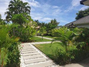 a garden with a stone pathway and palm trees at Beachfront Private VILLA & POOL in Banjar