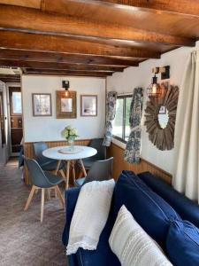 Una sala de estar con un sofá azul y una mesa. en Driftwood Cozy Houseboat on the Water for 2, en Savanna