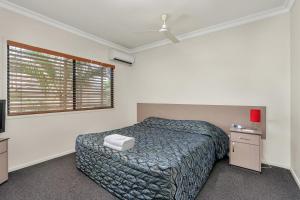 a small bedroom with a bed and a window at Western Gateway Motel and Apartments in Emerald