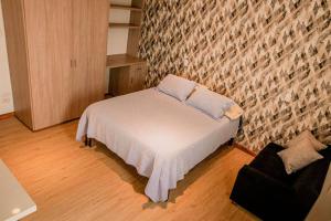 Cama pequeña en habitación con pared de ladrillo en Hermoso Apartamento amoblado, excelente ubicación, en Manizales