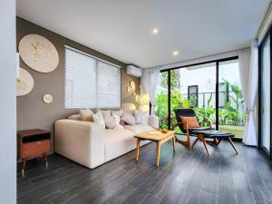 a living room with a white couch and a table at Asri Cinta Villa Ubud in Ubud