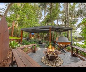 a fire pit with a picnic table and benches at 5 bedroom Terrigal beach home with district views in Terrigal