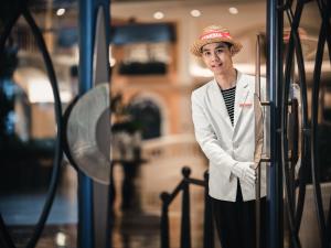 a woman wearing a hat standing next to a bus at Hotel Indigo Shenzhen Overseas Chinese Town, an IHG Hotel in Shenzhen