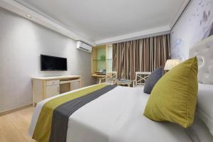 Una habitación de hotel con una cama grande y un televisor. en Cheng yue International Hotel, en Guangzhou