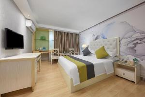 Una habitación de hotel con una cama grande y un escritorio. en Cheng yue International Hotel, en Guangzhou