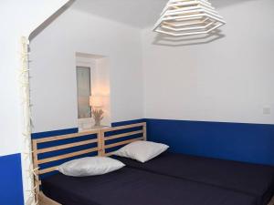 プルームール・ボドゥーにあるMaison Pleumeur-Bodou, 5 pièces, 8 personnes - FR-1-368-68の青と白の客室で、ベッド1台と照明が備わります。