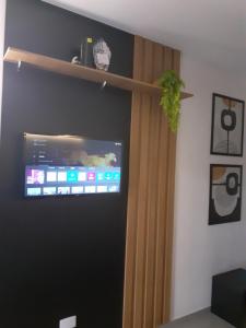 Habitación con TV en la pared en FLAT ENCANTADOR A UM PASSO DA PRAIA, en Salvador