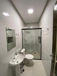 a bathroom with a toilet and a sink and a shower at Hotel Castanhal in Castanhal