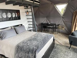 Canyon Rim Domes - A Luxury Glamping Experience!! في مونتيسلو: غرفة نوم بسرير وطاولة في غرفة