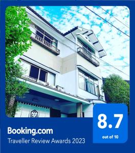 una imagen de una casa blanca con las palabras premios de revisión de viajes en ゲストハウス　華屋 (guest house HANAYA）, en Sado