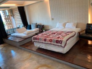 a bedroom with a bed and a couch in it at Daban Six Guest House in Nanwan