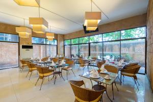 a restaurant with tables and chairs and large windows at Bella Villa Prima in Pattaya Central