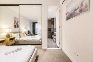 a bedroom with a bed and a living room at KULA South Yarra in Melbourne