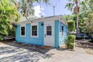 a blue and white house with palm trees at Beautiful Studio in Downtown Dunedin! in Dunedin
