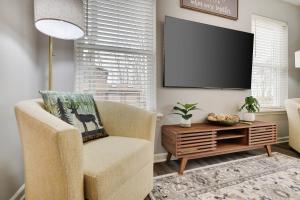 a living room with a chair and a flat screen tv at Modern 5BR, Kid-Friendly Home In Poconos with Pool Table in East Stroudsburg