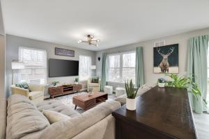 a living room with a large couch and a tv at Modern 5BR, Kid-Friendly Home In Poconos with Pool Table in East Stroudsburg