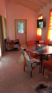 a living room with a glass table and chairs at El Palacio Apartments in Bridgetown