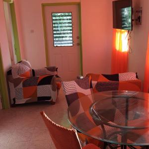 a living room with a glass table and chairs at El Palacio Apartments in Bridgetown