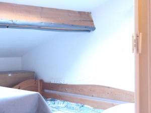 um quarto com uma cama e um corrimão de madeira em Maison Gruissan, 1 pièce, 4 personnes - FR-1-229-841 em Gruissan