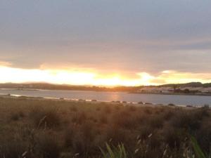 um pôr-do-sol sobre uma massa de água com um campo em Maison Gruissan, 1 pièce, 4 personnes - FR-1-229-841 em Gruissan