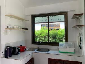 俊島的住宿－Koh Jum Paradise Resort，厨房设有水槽和窗户。